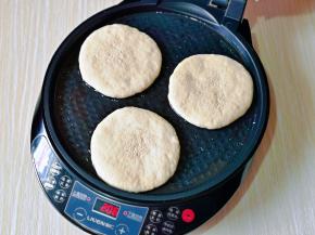 电饼铛刷上少许食用油，摆放上饼胚，选择大饼功能，盖上盖子。