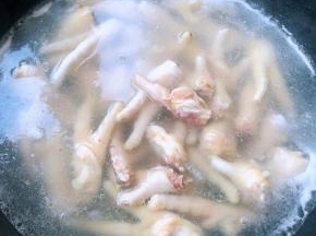 鸡爪剁成块状放入开水中焯水至鸡爪变色去除血水和杂质后立即放入冷水中过凉多冲洗几遍沥干水份