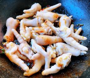 放入鸡爪大火快速翻炒均匀