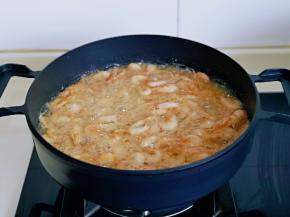 锅中加入食用油，待油温6成热时再加入虾，中火炸。