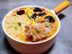 面条和猪排骨放入容器中均匀的淋上鸡蛋西红柿汤就大功告成了