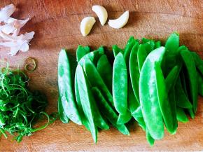 依次摘洗好所有的荷兰豆，蒜去皮。