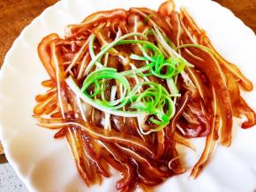 把烧好的热油淋在猪耳丝上，撒上葱丝。
