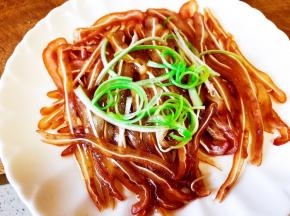 把烧好的热油淋在猪耳丝上，撒上葱丝。
