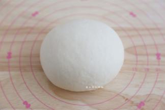 将汉堡面包胚的材料除黄油外揉成粗膜状态，再加入黄油揉出手套膜后，滚圆静置松弛15分钟。