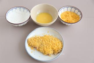 将腌制好的猪排切小块一些，按照生粉，蛋液，黄金面包糠的顺序逐一裹好。