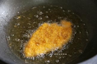 锅里倒入适量的食用油，放入一个面包糠试一下油温，能冒气泡就可以将猪排下锅了，小火慢炸5分钟左右，表面金黄即可出锅，用厨房用纸吸干多余的油。
