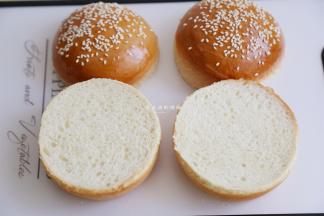 用锋利的面包刀把汉堡胚一分为二，记得高度要一致，做出来的汉堡才精致哦。