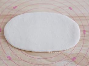 取出松弛好的面团，取一个，擀成长舌状，看到有气泡的地方要拍走气泡哦。