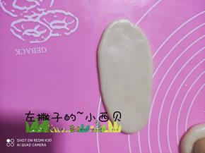拿一个包好的面团有上到下擀成牛舌状，
