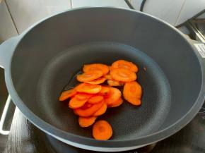 起锅热油，下胡萝卜片煎熟。