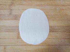 取一个小剂子压扁，擀成椭圆形。