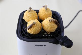 然后把土豆泥放在空炸杯的炸板上，一次放四个，盖上玻璃罩。