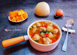 美味诱人的冬瓜胡萝卜肉丸汤装入容器中搭配馒头、鸡蛋、水果就是标配的早餐