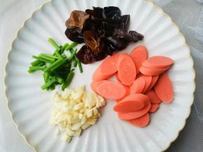 木耳提前泡发，火腿肠切片，葱切段，蒜切末。