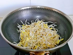 待蒜末炒出香味后加入豆芽翻炒。