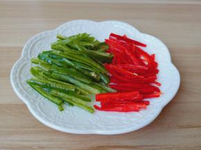 青红尖椒用刀划一个口，把辣椒籽去掉再切成丝。