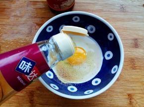 鸡蛋一个磕入碗中。加入盐、胡椒粉、料酒搅拌均匀。另一个打入米饭中，搅拌均匀。
