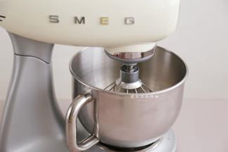 把蛋白放入SMEG厨师机里，先启动3档搅拌出大鱼泡眼的状态，倒入细砂糖，转到6档搅拌到出现细腻泡沫，倒入第二次细砂糖，7档搅拌半分钟左右倒入最后一次细砂糖和玉米淀粉，注意观察状态，出现纹理调到低速。