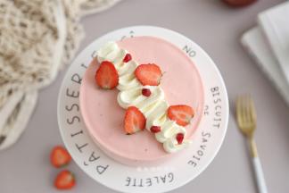 第二天用吹风机吹两圈，底下垫一个口杯，从上往下推即可脱模，打发50克的淡奶油，挤上奶油和草莓装饰，蛋糕就做好了。