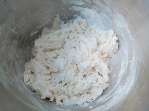 面粉里一边倒温水一边用筷子搅拌成絮状。