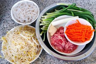 准备原材料豆芽、煮八成熟的粉条、鲜肉、胡萝卜切成丝、韭菜、葱、姜