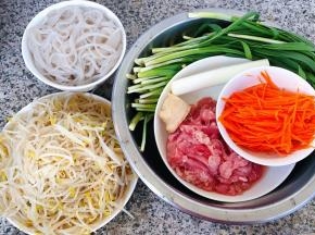 准备原材料豆芽、煮八成熟的粉条、鲜肉、胡萝卜切成丝、韭菜、葱、姜