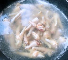 放入开水中焯水至鸡爪变色去除血水和杂质后立即放入冷水中过凉多冲洗几遍沥干水份


