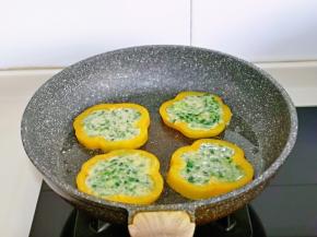 平底锅中刷少许食用油，摆放上黄椒圈，再盛去了面糊。