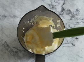 然后分出一小部分拌好的面糊，将之前融化好的牛奶黄油混合液体沿着刮刀倒入，用翻拌方式先小部分拌匀。