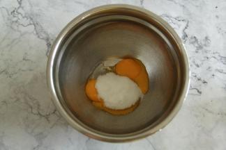 冷凉期间，准备英式奶油霜。将细砂糖倒入蛋黄中，用电动打蛋器，低速打到细砂糖融化。