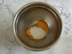 冷凉期间，准备英式奶油霜。将细砂糖倒入蛋黄中，用电动打蛋器，低速打到细砂糖融化。