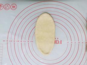 面团按扁后擀成牛舌状，边擀边排气