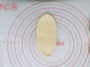 面团按扁后擀成牛舌状，边擀边排气