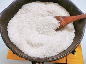 将粗颗粒海盐翻炒至水分收干，直到盐变黄发出哔哔卜卜的声音，炒至滚烫,盐色变黄