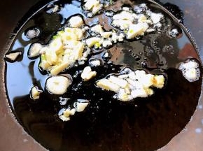 锅中倒入适量油加热放入蒜粒爆香