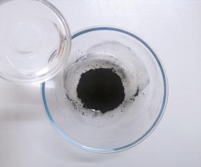 将竹炭粉倒入大碗中，加入清水搅拌均匀