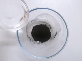 将竹炭粉倒入大碗中，加入清水搅拌均匀