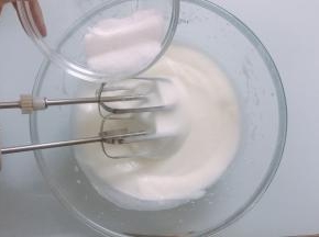电动打蛋器继续高速打至出现比较细腻的泡沫时，再加入三分之二细砂糖
