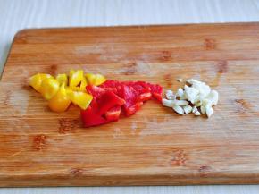 红黄椒洗干净，去根切小块，大蒜去皮切碎。