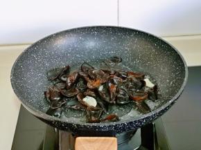 另起油锅，加入蒜炒香，再加入泡发的黑木耳翻炒。