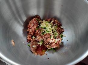 把肉馅放入厨师机桶内，高汤、姜末、葱末也一并放进去。（若家里没有高汤可放点鸡精提味）