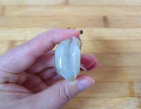 再将虾的背部用刀划开，挑出虾线清洗干净。