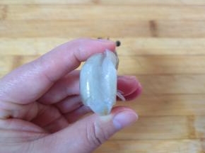 再将虾的背部用刀划开，挑出虾线清洗干净。
