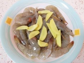 处理好的虾放进盘子里，加入料酒和生姜片搅拌均匀，腌制10分钟左右。