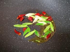 炒锅内倒适量的食用油烧热，下入蒜苗和干红辣椒爆香。