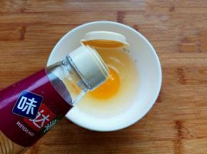 鸡蛋磕入碗中，加入盐、料酒搅拌均匀。