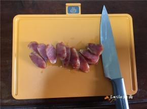 取出香肠，晾凉切成片。