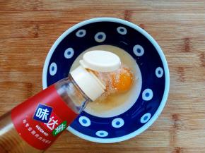 鸡蛋磕入碗中，加入盐、胡椒粉、料酒搅拌均匀。