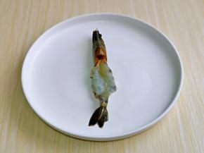 黑虎虾挑出虾线，把虾身上的皮去掉，头尾留下，如图。